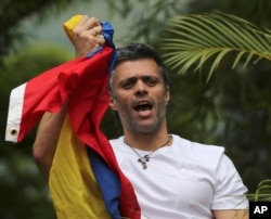 FILE - Venezuela's opposition leader Leopoldo Lopez holds a national flag as he greets supporters outside his home in Caracas, Venezuela, following his release from prison, July 8, 2017..