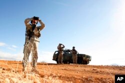FILE - In this Jan. 19, 2007, photo, a National Guard unit patrols at the U.S.-Mexico border in Sasabe, Arizona.