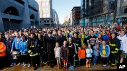A crowd gathers at the finish line of the Boston Marathon in Boston for a Sports Illustrated photo shoot before the one-year anniversary of the Boston Marathon bombings, April 12, 2014. 