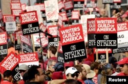 Ribuan anggota dan pendukung Writers Guild of America memegang poster selama pemogokan besar-besaran di luar studio Fox di sepanjang Avenue of the Stars di Los Angeles, California, 9 November 2007. (Foto: Reuters)