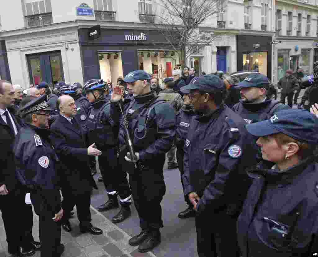 French interior minister Bernard Cazeneuve (third left) meets police officers during a visit to Rue des Rosiers in the heart of the Paris Jewish quarter, Jan. 12, 2015.