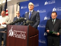 FILE - Washington Gov. Jay Inslee, center, speaks at a news conference in Shoreline, Wash.