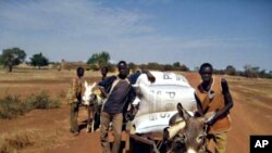 Farmers in Burkina Faso haul their harvest stored in airtight bags.