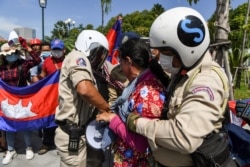 រូប​ឯកសារ៖ កងសន្ដិសុខ​រឹបអូស​ឧបករណ៍​បំពង​សំឡេង​ពី​បាតុករ​ម្នាក់ ក្នុង​អំឡុងពេល​នៃ​ការ​ធ្វើ​បាតុកម្ម​មួយ​ដើម្បី​ប្រារព្ធ​ខួប​ទី​២៩ នៃ​កិច្ចព្រមព្រៀង​សន្ដិភាព​ទីក្រុង​ប៉ារីស​នៅ​មុខ​ស្ថានទូត​សហរដ្ឋអាមេរិក រាជធានី​ភ្នំពេញ ​ថ្ងៃទី២៣ ខែតុលា ឆ្នាំ២០២០។