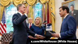 资料照片：在白宫椭圆形办公室，在特朗普总统注视下，前参议员庞德伟在夫人邦妮陪同下，在国务卿卢比奥面前宣誓就职，出任美国驻中国大使。(2025年5月15日)