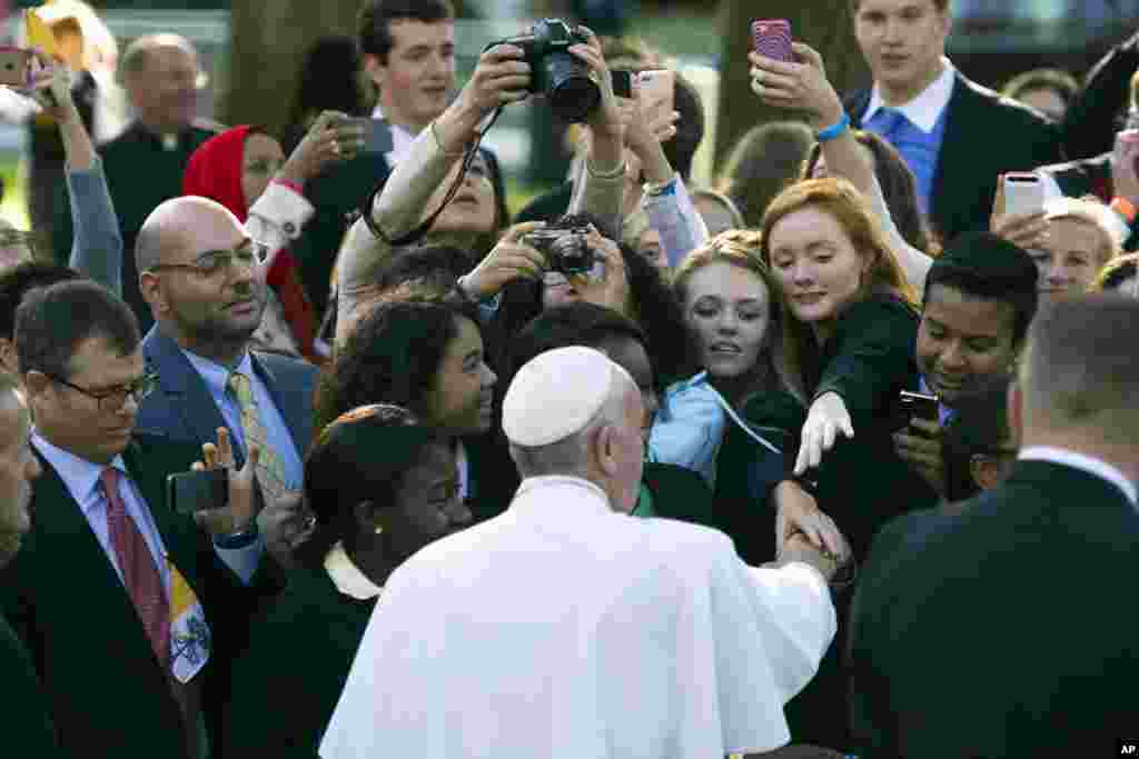 Pope Francis greets well-wishers while departing for the White House from the Apostolic Nunciature, the Vatican's diplomatic mission in Washington, Sept. 23, 2015.