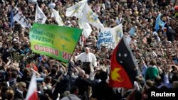 Pope Francis waves as he leaves after the Palm Sunday mass at Saint Peter's Square at the Vatican, March 24, 2013.