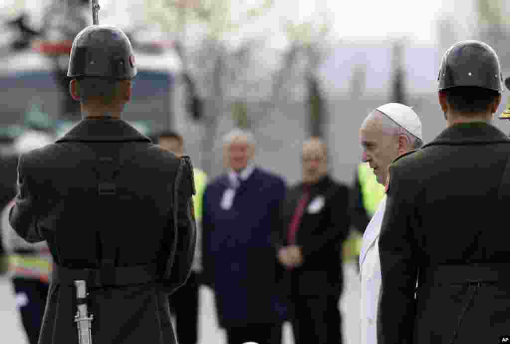 Pope Francis walks past the honor guard as he arrives at the Esenboga airport in Ankara, Friday, Nov. 28, 2014.