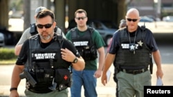 FILE - Officers arrive at the Orlando Police Headquarters during the investigation of a shooting at the Pulse nightclub in Orlando, Florida, June 12, 2016.