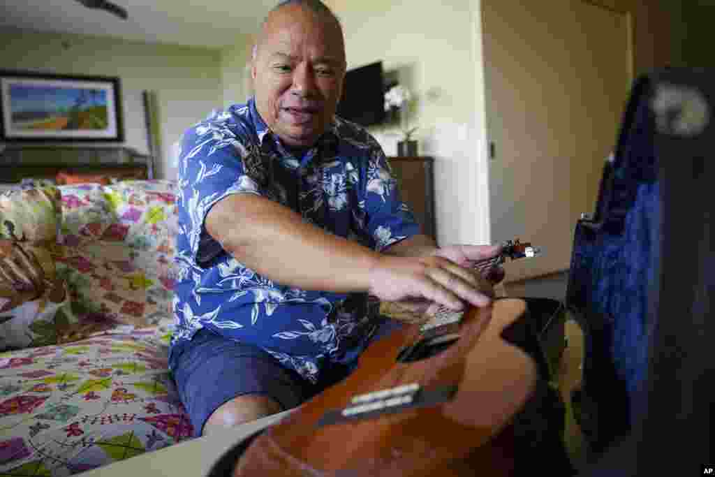 Charles Nahaale holds a ukulele gifted by his friend after Nahale lost most of his instruments from August's wildfire on Oct. 10, 2023, in Lahaina, Hawaii.&nbsp;