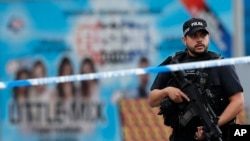 FILE - Armed police officers patrol a police cordon near the Manchester Arena in Manchester, May 24, 2017. 
