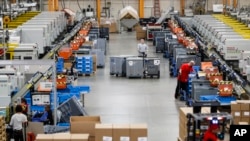 In this May 25, 2017 photo, employees work a factory floor at a Stihl Inc. production plant in Virginia Beach, Va. There are assembly lines at the Stihl plant, but human workers are interspersed with computers and robotics. (AP Photo/John Minchillo)