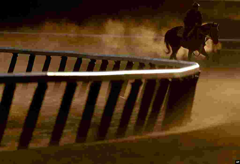 Seorang penunggang kuda balap berlatih di sekeliling jalur balapan di Elmont, New York.&nbsp; Balapan kuda Belmont Stakes ke-149 yang diselenggarakan hari Sabtu.