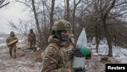 Anggota Brigade Serbu Terpisah ke-3 (Unit Azov) Angkatan Bersenjata Ukraina bersiap menembakkan howitzer 152 mm 2A65 Msta-B, di tengah serangan Rusia terhadap Ukraina, dekat Bahmut, di wilayah Donetsk, Ukraina, 6 Februari 2023. (REUTERS/ Marko Djurica)