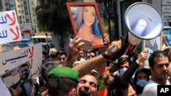 A Lebanese man who lost a son during the last year's massive blast at Beirut's seaport shouts slogans as he's pushed back by a Lebanese soldier as he tries with others to reach the residence of parliament speaker Nabih Berri, in Beirut on July 9, 2021.