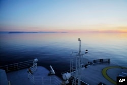 In this July 14, 2017 file photo, The Finnish icebreaker MSV Nordica sails past the American island of Little Diomede, Alaska, left, and behind it, the Russian island of Big Diomede, separated by the International Date Line on the Bering Strait.