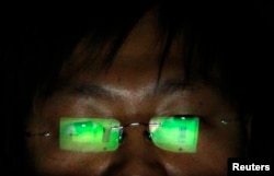 FILE - A hacker, who requests not to have his name revealed, works on his laptop in his office in Taipei.
