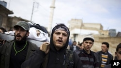 Free Syrian Army fighters carry the body of a comrade killed by the Syrian Army in Azaz, Syria, Dec. 13, 2012