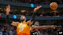 Toronto Raptors forward OG Anunoby (3) knocks the ball from Utah Jazz center Rudy Gobert (27) as he drives to the basket in the second half during an NBA basketball game, March 9, 2020, in Salt Lake City. 