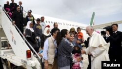 Pope Francis welcomes a group of Syrian refugees after landing at Ciampino airport in Rome following a visit at the Moria refugee camp in the Greek island of Lesbos, April 16, 2016. 