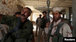 Fighters of the Syria Democratic Forces (SDF) stand inside a building near Manbij, in Aleppo Governorate, Syria on June 17, 2016. 