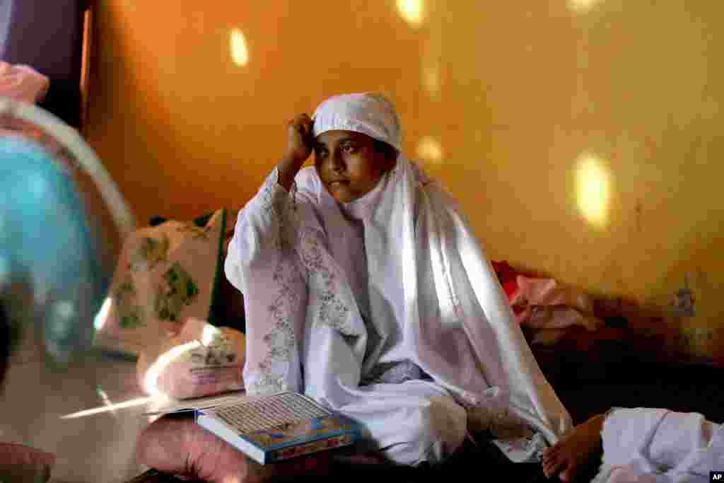 A migrant woman sits after praying at a temporary shelter in Lhoksukon, Aceh province, May 21, 2015.