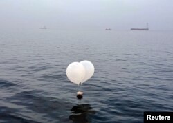 Sebuah balon yang membawa berbagai benda termasuk sampah, yang diyakini dikirim oleh Korea Utara, terlihat di laut lepas Incheon, Korea Selatan, 9 Juni 2024. (Yonhap via Reuters)