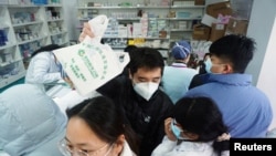 Orang-orang mengantre untuk membeli alat tes antigen COVID-19, di sebuah apotek di Hangzhou, Provinsi Zhejiang, China, 19 Desember 2022. (Foto: China Daily via REUTERS)