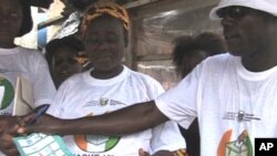 Educators teach female street vendors how to properly fold a ballot after marking their candidate so the ink will not smudge into multiple boxes, rendering the vote invalid
