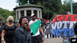 រូបឯកសារ៖ បាតុករ​ម្នាក់ (ខាងមុខគេ) ស្រែក​ទទូច​ឲ្យ​អ្នកតវ៉ា​ផ្សេង​ឲ្យ​ក្រោកឈរ​ឡើង ដើម្បី​ក្លាយជា​សកម្មជន​ក្នុង​អំឡុងពេល​ជួបជុំ​នៃ​ចលនា Black Lives Matter ដែល​ធ្វើ​ឡើង​នៅ​ទីលាន Grand Army Plaza ក្នុង​សង្កាត់ Brooklyn ទីក្រុង​ញូវយ៉ក។