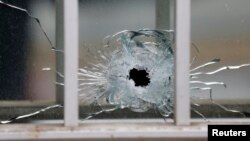 A bullet's impact is seen on a window at the scene after a shooting at the Paris offices of Charlie Hebdo, a satirical newspaper, Jan. 7, 2015. 