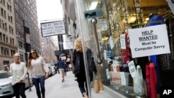 FILE - A "Help Wanted" sign hangs in a store window in New York. 