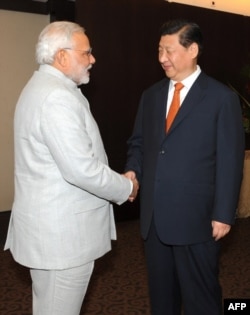 In this photograph received from the Press Information Bureau (PIB) and taken on July 14, 2014, Indian Prime Minister Narendra Modi (L) shakes hands with Chinese President Xi Jinping during the BRICS summit in Fortaleza, Brazil.