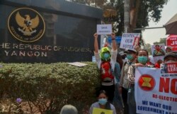 Pengunjuk rasa membawa poster-poster berdemo dekat Kedutaan Besar Indonesia di Yangon, Myanmar, 24 Februari 2021. (Foto: AP)