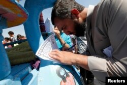 A man signs a form for the pro-Morsi Tagarod (impartiality) campaign in Amr Bin Aaas mosque in Cairo, June 14, 2013. The campaign was started in response to counter the Tamarod (rebellion) petition started by anti-Morsi supporters to withdraw confidence in the president.