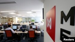 FILE - Traders work on the floor of the Moscow Exchange, June 3, 2014.