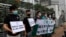 FILE - Members of the Democratic Party hold banners and placards during a protest in front of the Chinese central government's liaison office in Hong Kong, May 22, 2020. 
