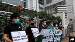Members of the Democratic Party hold banner and placards during a protest in front of the Chinese central government's liaison office in Hong Kong, May 22, 2020. 