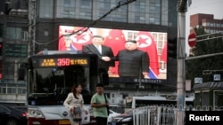 A television screen shows Chinese state media CCTV's footage of North Korean leader Kim Jong Un's meeting with Chinese President Xi Jinping in Pyongyang, at a street in Beijing, China, June 20, 2019