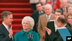 Presiden George H.W. Bush saat dilantik sebagai presiden AS ke-41 di depan Capitol didampingi oleh istrinya, Barbara Bush, yang memegang Alkitab untuk suaminya, 20 Januari 1989.
