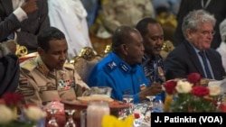 Militia commander Mohamed Hamdan Hemeti Dagolo (left, in khaki uniform) eats an Iftar meal with U.S. Charge D'Affaires Steven Koutsis (far right, in suit), in Khartoum, Sudan, May 18, 2019.