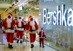Warga mengenakan kostum Sinterklas saat berjalan-jalan di pusat perbelanjaan di tengah pandemi COvid-19 di Jakarta, 20 Desember 2020. (REUTERS/Ajeng Dinar Ulfiana)
