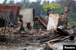 Children recycle goods from the ruins of a market which was set on fire at a Rohingya village outside Maugndaw in Rakhine state, Myanmar, Oct. 27, 2016.