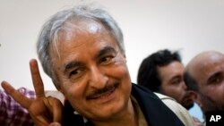 FILE - In this Friday, March 18, 2011 file photo, then Libyan senior Rebel commander Khalifa Hifter leaves a press conference in the court house in the center of Benghazi, eastern Libya.