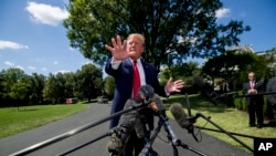 President Donald Trump speaks with reporters before departing on Marine One on the South Lawn of the White House, Aug. 21, 2019, in Washington.
