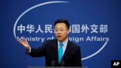 FILE - Chinese Foreign Ministry new spokesman Zhao Lijian gestures as he speaks during a daily briefing at the Ministry of Foreign Affairs office in Beijing, Feb. 24, 2020.