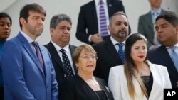 FILE - U.N. High Commissioner for Human Rights Michelle Bachelet poses for a photo with opposition lawmakers on the steps of the national assembly in Caracas, Venezuela, June 21, 2019. 