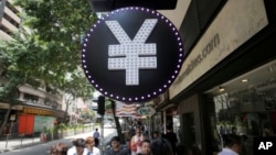 FILE - A Chinese yuan sign is seen at a currency exchange shop in Hong Kong, Aug. 11, 2015. 