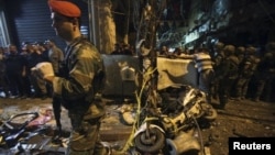 Residents and Lebanese army members inspect a damaged area caused by two explosions in Beirut's southern suburbs, Lebanon, Nov. 12, 2015. 