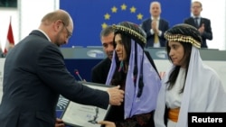 Nadia Murad Basee Taha (C) and Lamiya Aji Bashar (R), both Iraqi women of the Yazidi faith receive their 2016 Sakharov Prize from European Parliament President Martin Schulz (L) during an award ceremony at the European Parliament in Strasbourg, France, De
